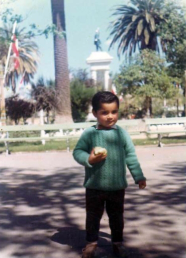 Niño posa en Plaza de Armas - estatua Ignacio Serrano